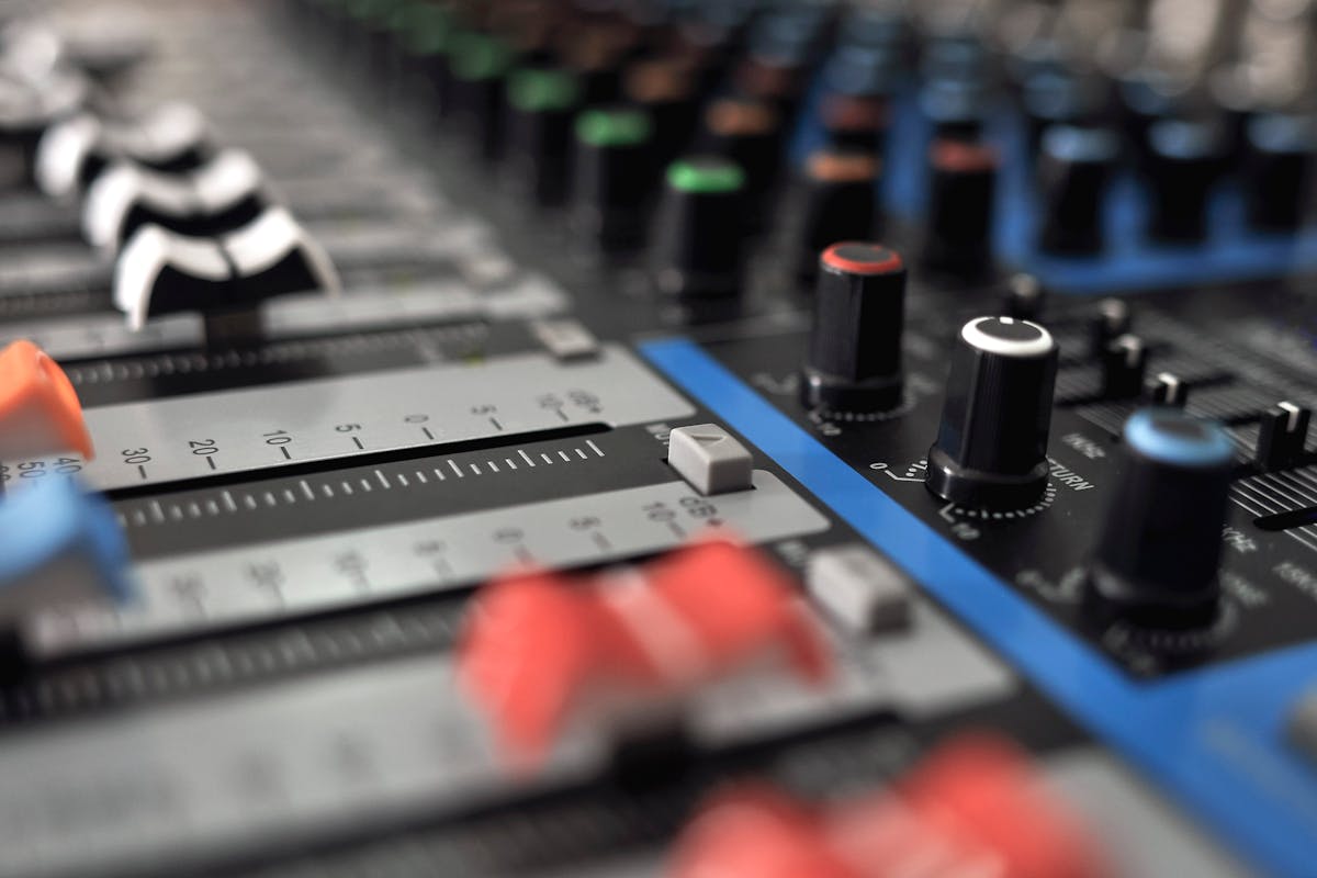 Professional audio mixing board with faders lit up during a live event